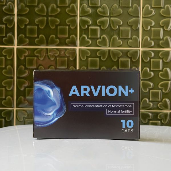 Jedna krabička Arvion+ s údajom 10 caps na bielom mramorovom stolíku pred zelenými reliéfnymi kachličkami