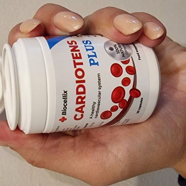Biela dóza Cardiotens Plus značky Biocellix s červenými krvinkami na etikete a odklopeným viečkom, položená v ženskej dlani