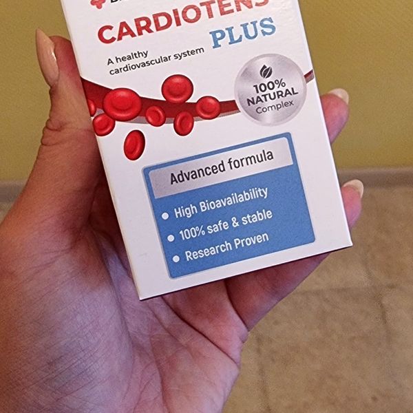 Krabička Cardiotens Plus položená na otvorenej dlani, vidno jej spodnú polovicu s modrým rámčekom