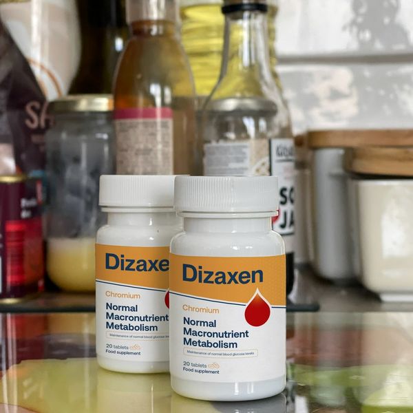 Dve fľaštičky Dizaxen na sklenenej doske v kuchyni, za nimi fľaše s olejom a zavárací pohár