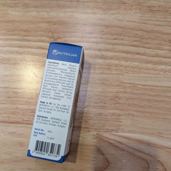 Bočná strana krabičky Flexosamine PRO so zoznamom zložiek, údajmi o distribútorovi a čiarovým kódom na drevenom stole