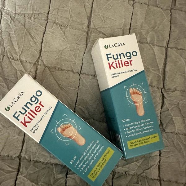 Dve bielo-tyrkysové krabičky Fungokiller 50 ml s kresbou chodidla položené na sivej prešívanej prikrývke